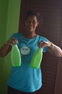 Mujeres Unidas member Wendy poses for a picture as she fills bottles with homemade detergent during one of the training courses. 