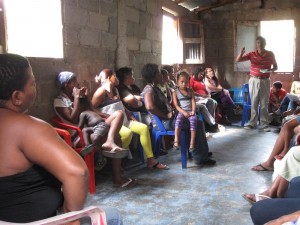 Members of Mujeres Unidas work with representatives of CIAMF at a community meeting in January March 2014