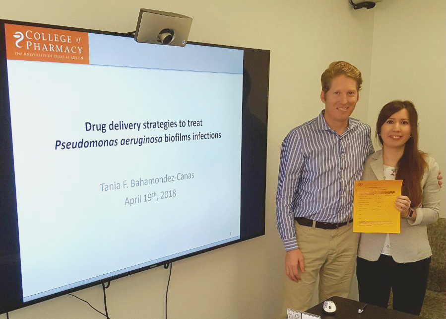 Dr. Tania Bahamondez-Canas standing with Dr. Smyth next to a presentation screen