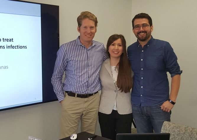 Dr. Tania Bahamondez-Canas, Dr. Smyth, and a third person standing in front of a presentation screen.