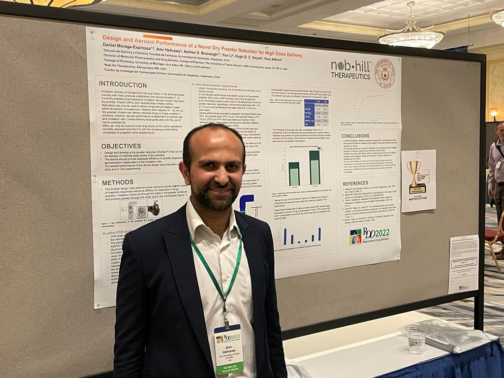 Amr Hefnawy standing in front of his research poster after presenting his work on a novel dry powder nebulizer.