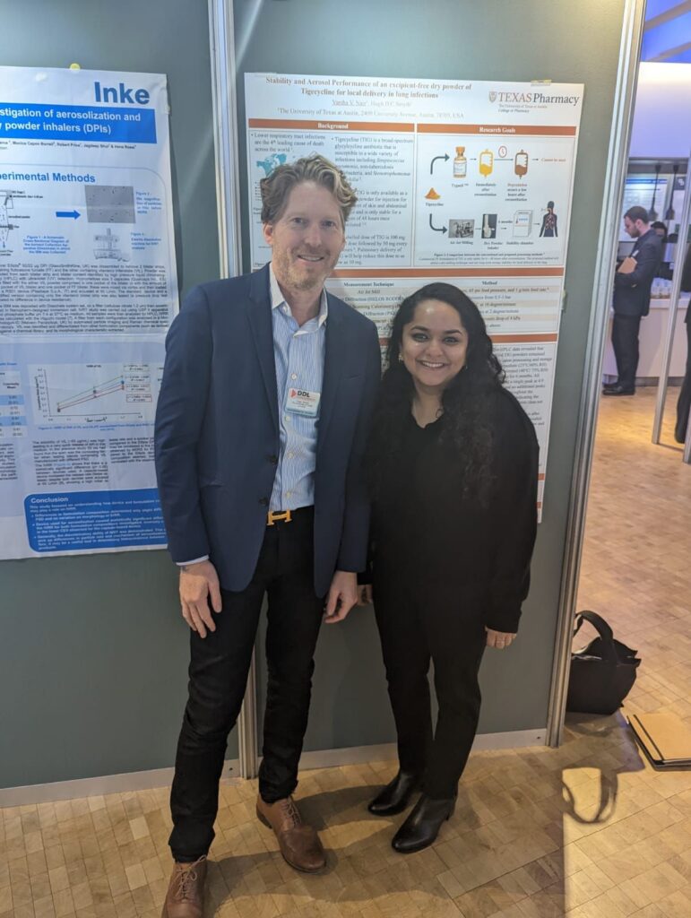 Dr. Smyth and Varsha Nair standing in front of research poster at DDL conference 2022.