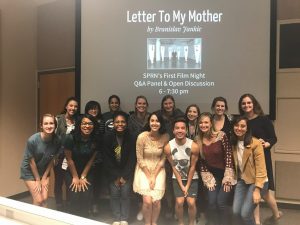 Group of students standing in front of projection screen with text, "Letter To My Mother"