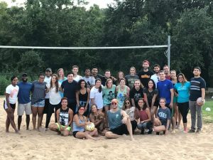 Large group of students on sand volleyball court