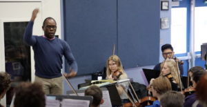 Orchestra Teacher Rickey Pringle directing High School Students