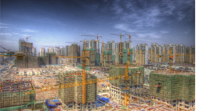 Illustration of cityscape with multiple cranes erecting high-rise buildings.