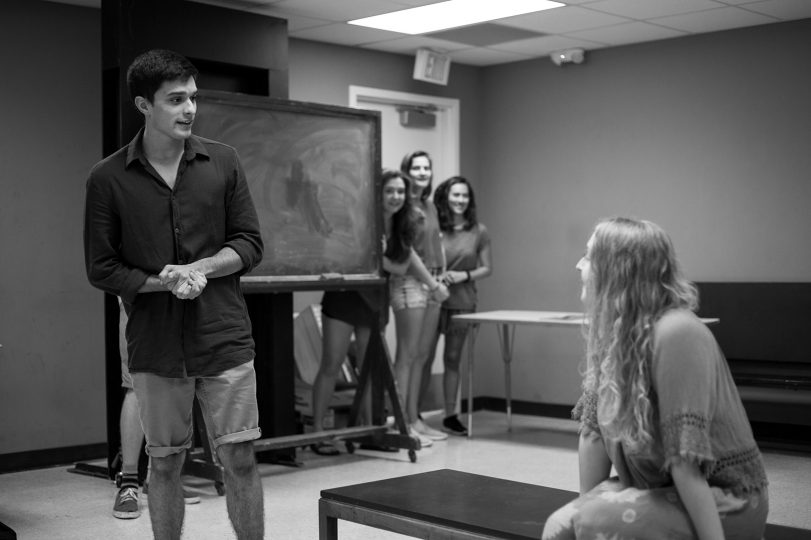 student standing in a class in front of a chaulkboard