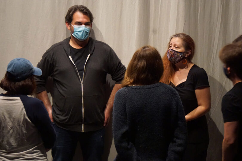 group of collaborators wearing face masks standing in a circle