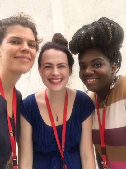 three UT graduate students pose together before co-leading the 2019 Applied Drama Institute