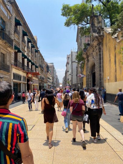 students walking through Colonia Centro, a street lined with buildings on either side