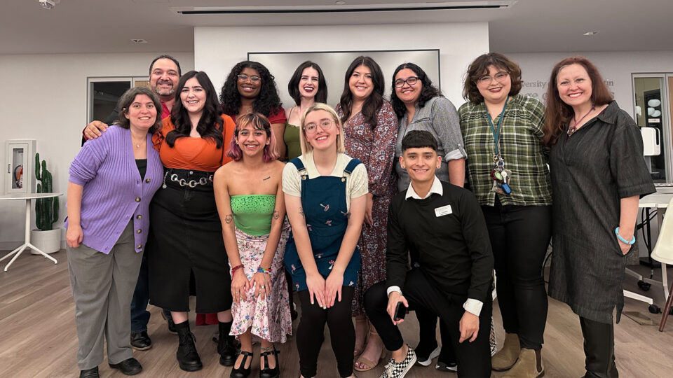 UTeach Theatre graduates smile, standing in two lines with their UTeach professors at an end-of-year celebration