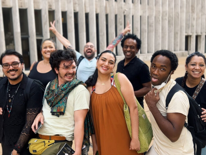 A group of eight Candela Playwrights Summer Fellows pose joyfully together