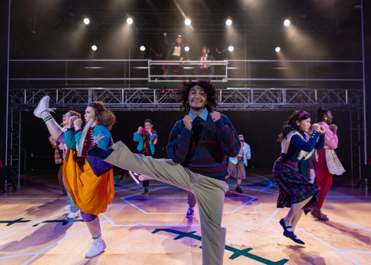 The cast of A Beautiful Day in November on the Banks of the Greatest of the Great Lakes all kick out to the side, photographed in the middle of their jazz-ercise routine.