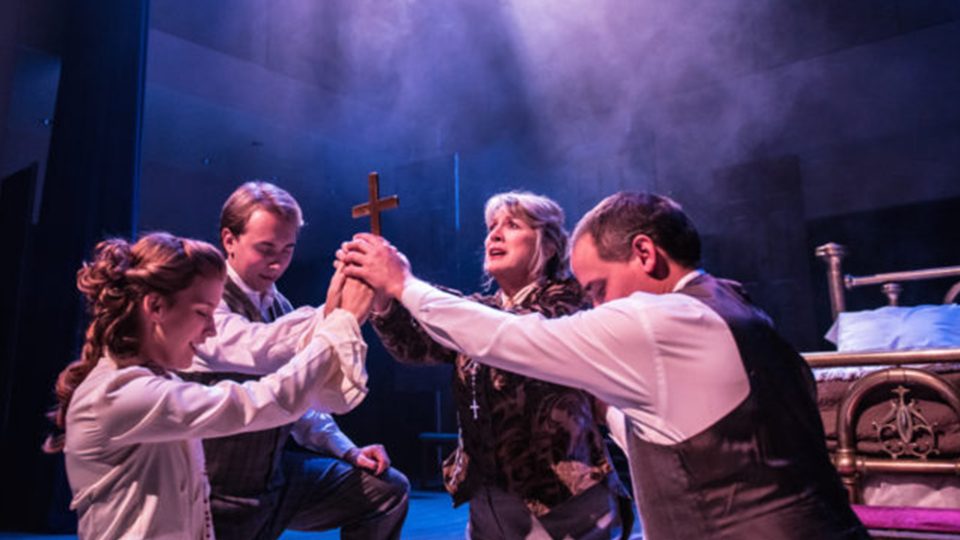 people huddle around crucifix in dracula by steven dietz