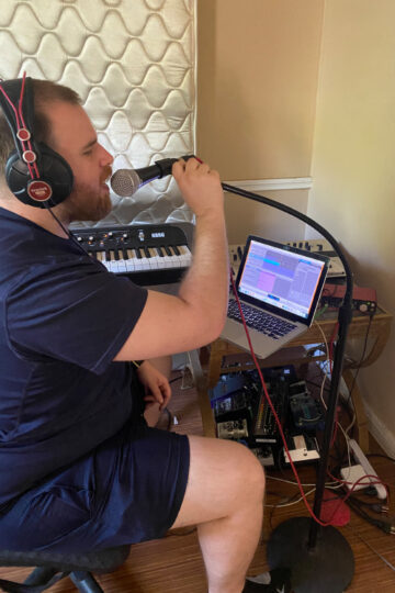 Man singing into microphone on home setup