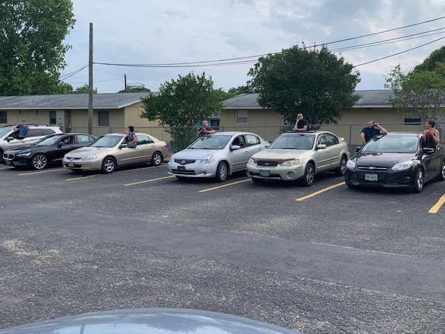 students and faculty posing through their car windows