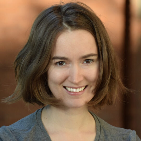 woman with short light brown hair wearing a grey shirt