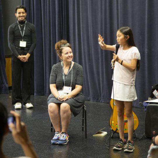 Faculty member Roxanne Schroeder-Arce and undergraduate Yobany Pizano what a summer camp participant talk about her experience