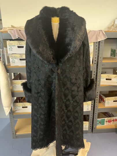 A thick black coat with a faux fur collar, stitched by Marisa Lawrence