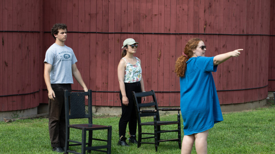 Caley Chase works with actors on an outdoor stage during a rehearsal for MACBETH