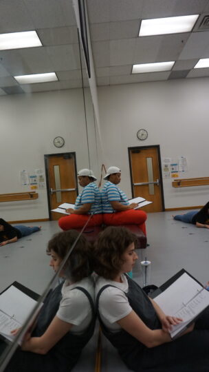 Playwright Claire Derriennic and director Renita James sit leaning against a wall of mirrors during rehearsals for TASTE BUDS