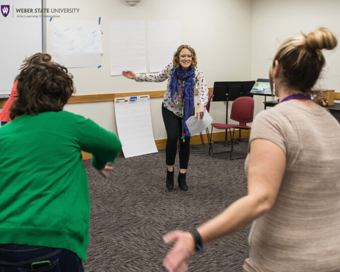 Lara Dossett leads a movement-based session at a conference with fellow educators
