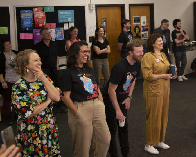 Lara Dossett stands and laughs with three other faculty members