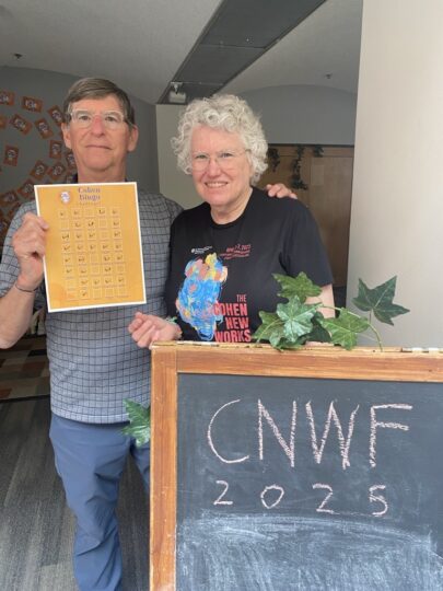Alice and Chip Gentry stand in front of a Cohen New Works Festival Sign 