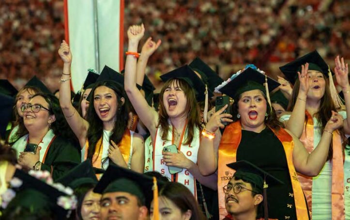 Students in commencement regalia celebrating