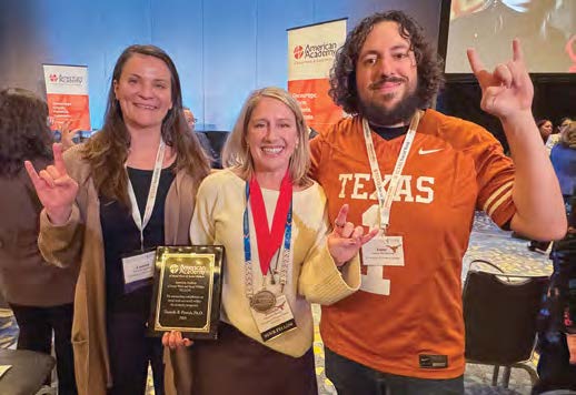 Dr. Parrish and students celebrating the AASWSW induction, showing Hook 'Em Horns sign.