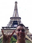 Student giving hook 'em horns sign in front of Eiffel Tower
