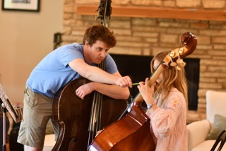 Photo of UTeach Music student teaching a cello lesson to a 2nd grader 