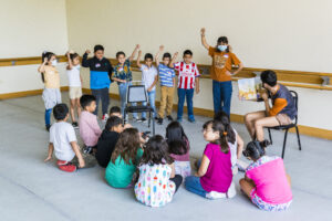 Photo of UTeach Theatre students leading a workshop with elementary students 