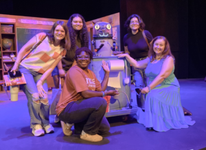 UTeach Theatre Students and Roxanne Schroeder-Arce with robot cat CC on stage at Magik Theatre.