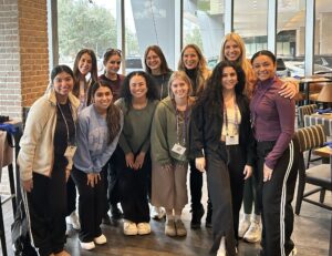 Group gathered in front of window. (L to R - back row) Sarah Johnston (Cohort 11), Claire Wood (Cohort 5), Hayley Jeansonne (Cohort 11), Dr. Tina Curran, Ashleigh Friday (Cohort 5), L to R - front row) Emily Figueroa (Cohort 11), Mia Bella Castillo (Cohort 10), Halle Hollingsworth (Cohort 9), Victoria Murillo (Cohort 5), Toni Neal (BFA Dance, Cohort 5 sibling).