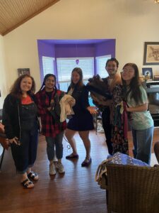Group photo of five holding donated clothes.