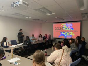 Presenters and Students at resource fair. Presentation on the projector. 