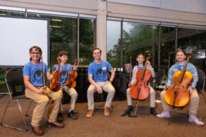 AJ Marks and his music student sitting for their musical performance